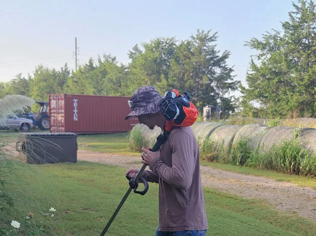 Good Sons Outdoor Services crew member trimming a lawn in Brenham, Texas